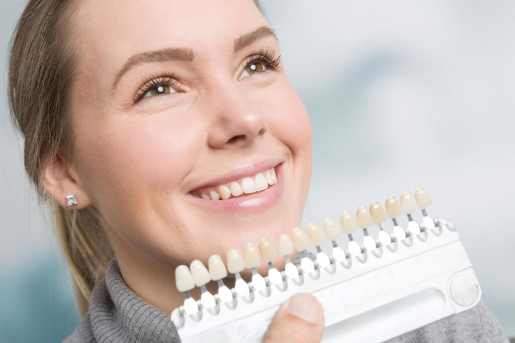 Close up of dentist using shade guide at woman's mouth